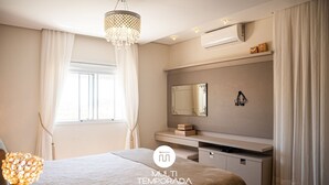 Een moderne slaapkamer met een bed, nachtkastje, kaptafel en een grote spiegel.