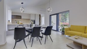 Cozinha moderna com área de jantar, um sofá amarelo e uma grande janela com vista.