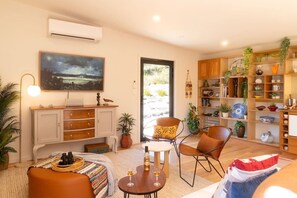 A modern living room with a sofa, chairs, a coffee table, and a bookshelf. - Studio 216 @Bruny ~Romantic, Beachfront & Secluded (Alonnah)