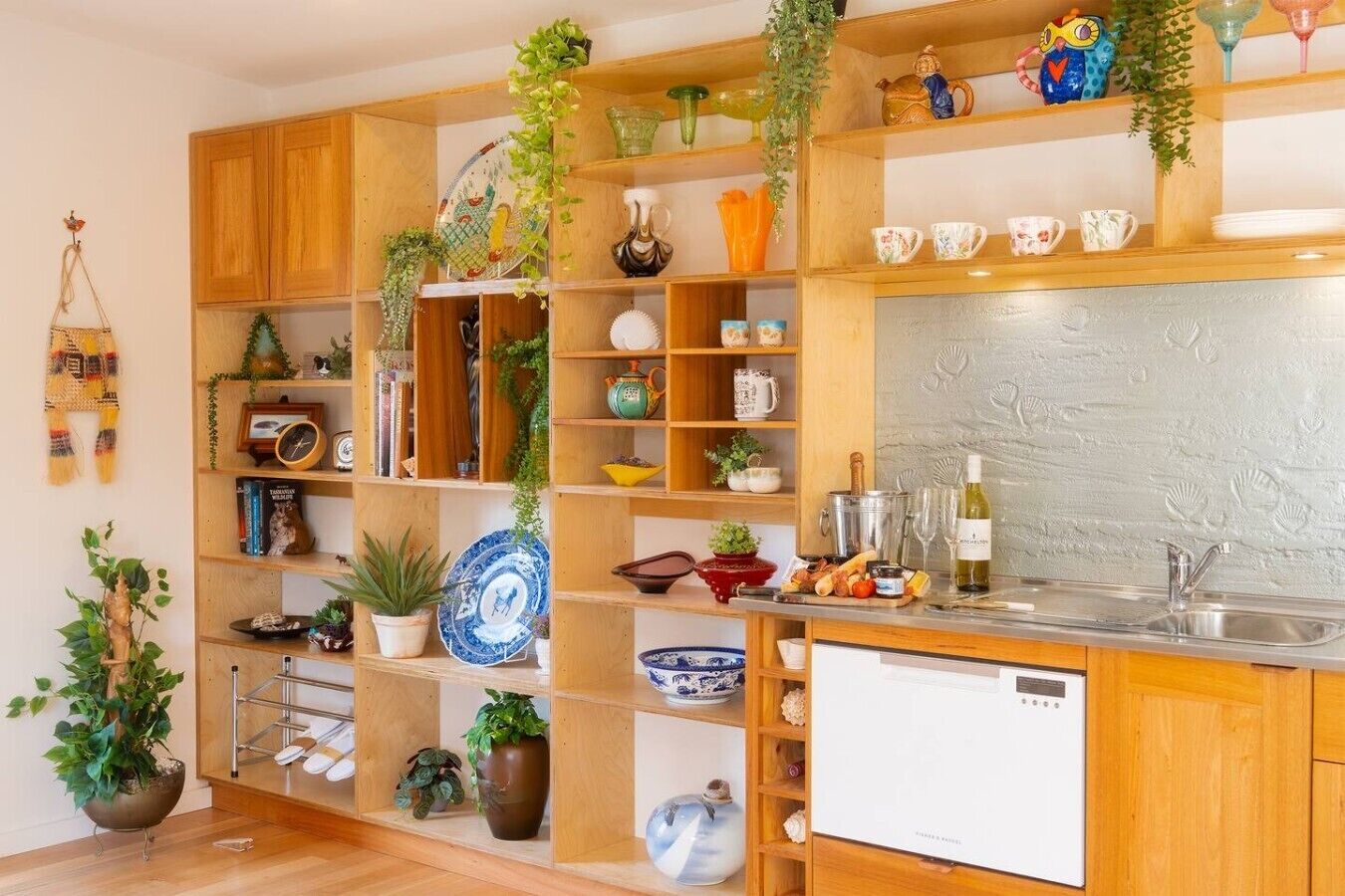 A kitchen with wooden cabinets, a white dishwasher, and various kitchenware.