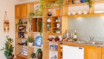 A kitchen with wooden cabinets, a white dishwasher, and various kitchenware.