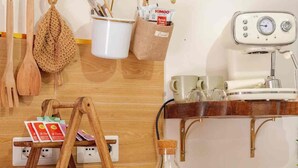 A kitchen with wooden utensils, a coffee machine, a bread display, and a hanging rack with kitchen tools. - Domus Auri Vatican Jacuzzi Boutique Stay (Roma)