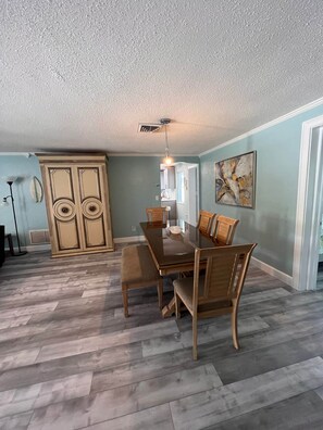 A dining area with a wooden table and chairs, a ceiling vent, and a light fixture. - Pet Friendly home with Hot Tub close to Beach (Largo)