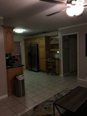 A kitchen with wooden cabinets, a stainless steel refrigerator, a trash can, and a ceiling fan. - Pet Friendly home with hot tub and access to Taylor Park (Largo)