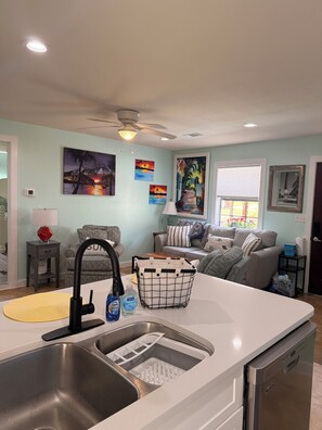 A kitchen with a sink, a ceiling fan, and a dining area with a table and chairs. - Peacfull 1 bedroom house with AC in charming Gulf Breeze (Gulf Breeze)
