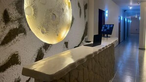 Una recepción con una escultura grande similar a la luna, un televisor de pantalla plana y un interior moderno.