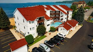 Un hotel su più piani con piscina, parcheggio e vista sull'oceano.