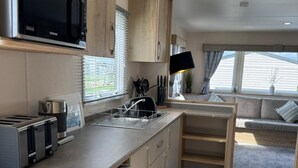 Une cuisine compacte équipée d’un four à micro-ondes, d’un grille-pain et d’un évier.