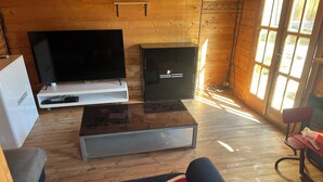 Una sala acogedora con un televisor de pantalla plana, un aparador, una mesa de centro y un sofá.