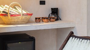 A kitchen area with a basket, coffee maker, and pots on a shelf. - Casa Calma, a unique space with an unparalleled location in downtown Merida (Mérida)