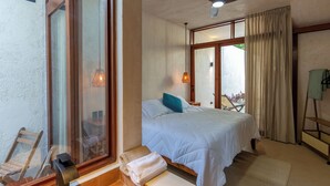 A bedroom with a bed, a window, a bathroom, and a view of the outside. - Casa Calma, a unique space with an unparalleled location in downtown Merida (Mérida)