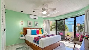 A bedroom with a bed, a ceiling fan, a window, and a view of the outside. - Casa 4 Estaciones (Puerto Morelos)