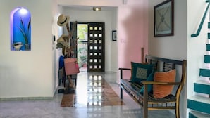 A hallway with a bench, a door, and a staircase. - Casa 4 Estaciones (Puerto Morelos)