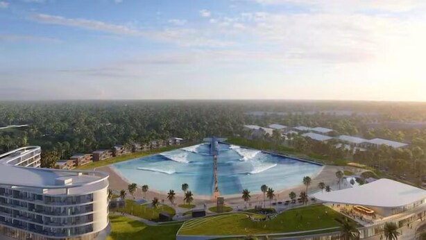 Un grand hôtel doté d’une piscine, entouré de verdure et offrant une vue sur l’océan.