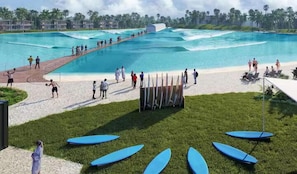 A swimming pool with a boardwalk, beach chairs, and surfboards. - Hutchinson Island Beach Retreat | Pets Welcome (Fort Pierce)