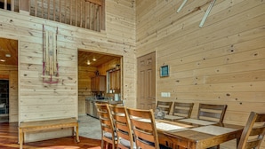 A wooden interior with a dining area, kitchen, and a loft space. - Gorgeous 4-bedroom cabin in enjoyable Summerhaven getaway +game room (Summerhaven)