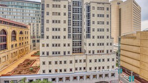 A multi-story building with a central elevator shaft, large windows, and a flat roof. - Deluxe One-Bedroom Apartment (Sandton)