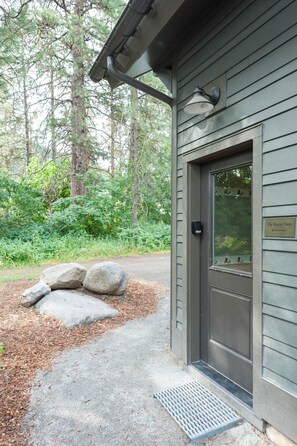 Un bâtiment avec une porte en métal, une petite fenêtre et une enseigne sur le mur.