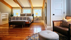A bedroom with a bed, bedside tables, a chair, and a window. - The Alley House (Leavenworth)