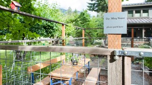 A wooden fence with a sign reading 'The Alley House please park here.' - The Alley House (Leavenworth)