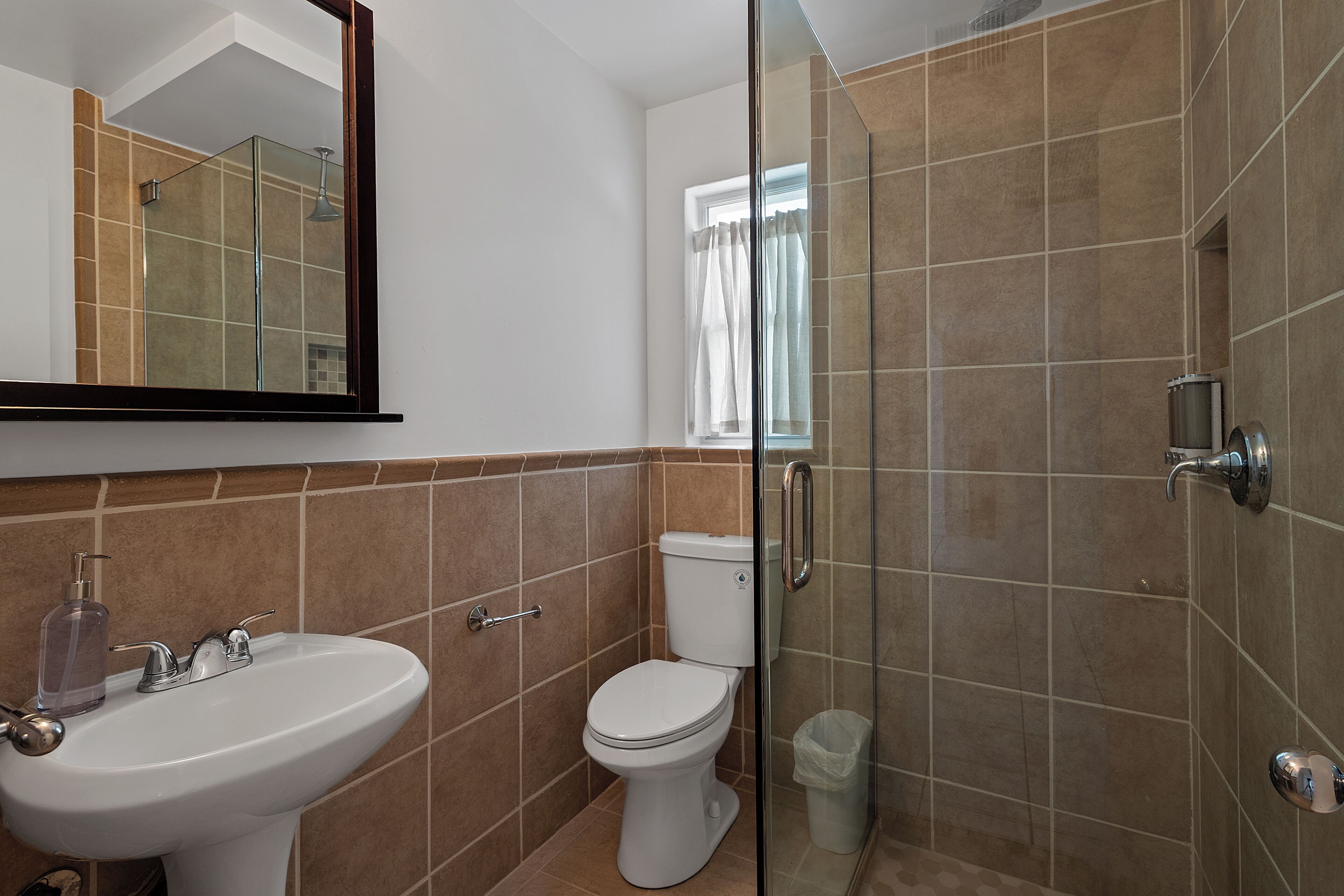 Un baño con lavamanos, inodoro y ducha.