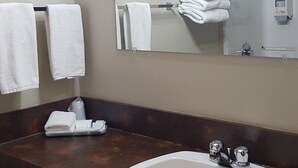 A bathroom with a sink, mirror, and stacked towels. - Retasket Lodge & RV Park (Lillooet)