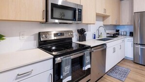 Een moderne keuken met roestvrijstalen apparatuur, witte kasten en een ingebouwde oven.