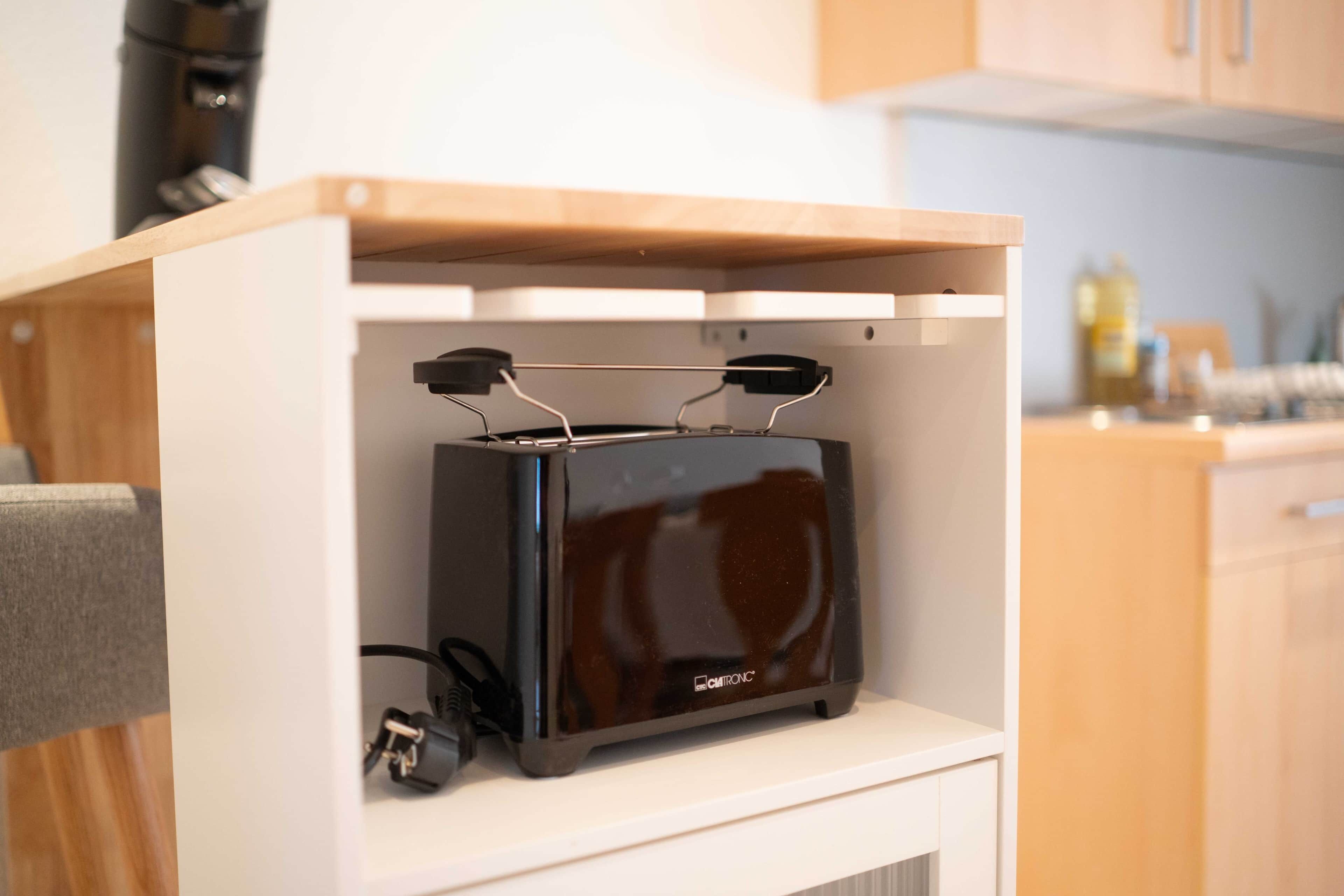 A compact kitchen with a built-in appliance, wooden cabinets, and a countertop.