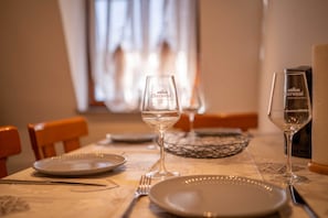 Ein Esstisch mit Tellern, Besteck und Gläsern, gedeckt für eine Mahlzeit.