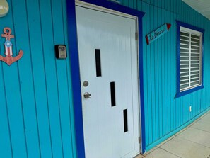 A turquoise building with a white door, a window with shutters, and a sign reading 'La Bicicleta.' - Family-Friendly Townhouse | Pool & Outdoor Dining (Cobo Rojo)