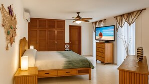 A bedroom with a bed, wooden wardrobe, TV, and a ceiling fan.