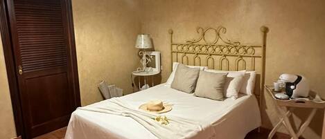A bedroom with a bed, a nightstand, a lamp, and a ceiling light fixture.