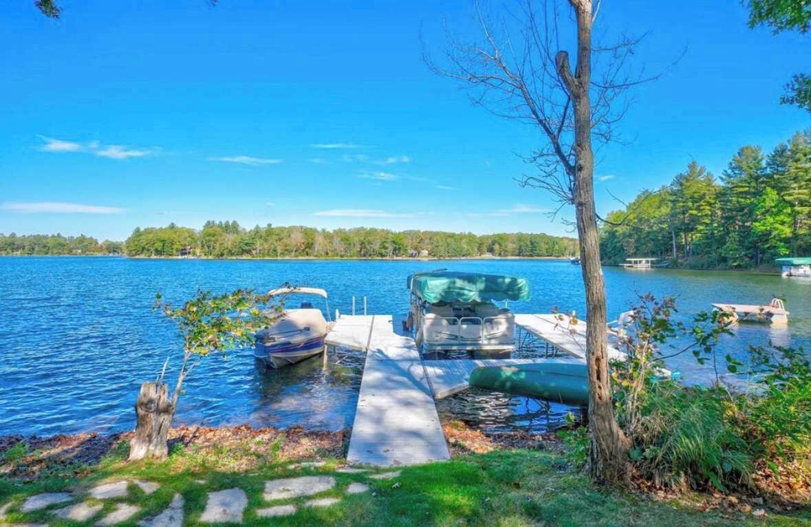 Private boat and swimming dock along shallow sandy beach on crystal clear Little Round Lake with easy boat access to the entirety of Round Lake.  
