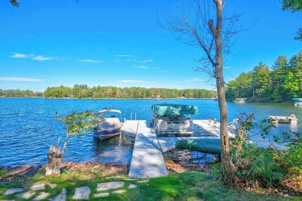 Private boat and swimming dock along shallow sandy beach on crystal clear Little Round Lake with easy boat access to the entirety of Round Lake.
