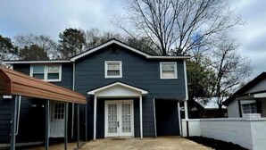 A two-story house with a covered porch, a garage, and a front door.