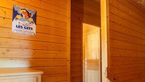 Ein Holzbalkon mit einem Feuerlöscher, einem Poster und einer Tür zu einem anderen Raum.