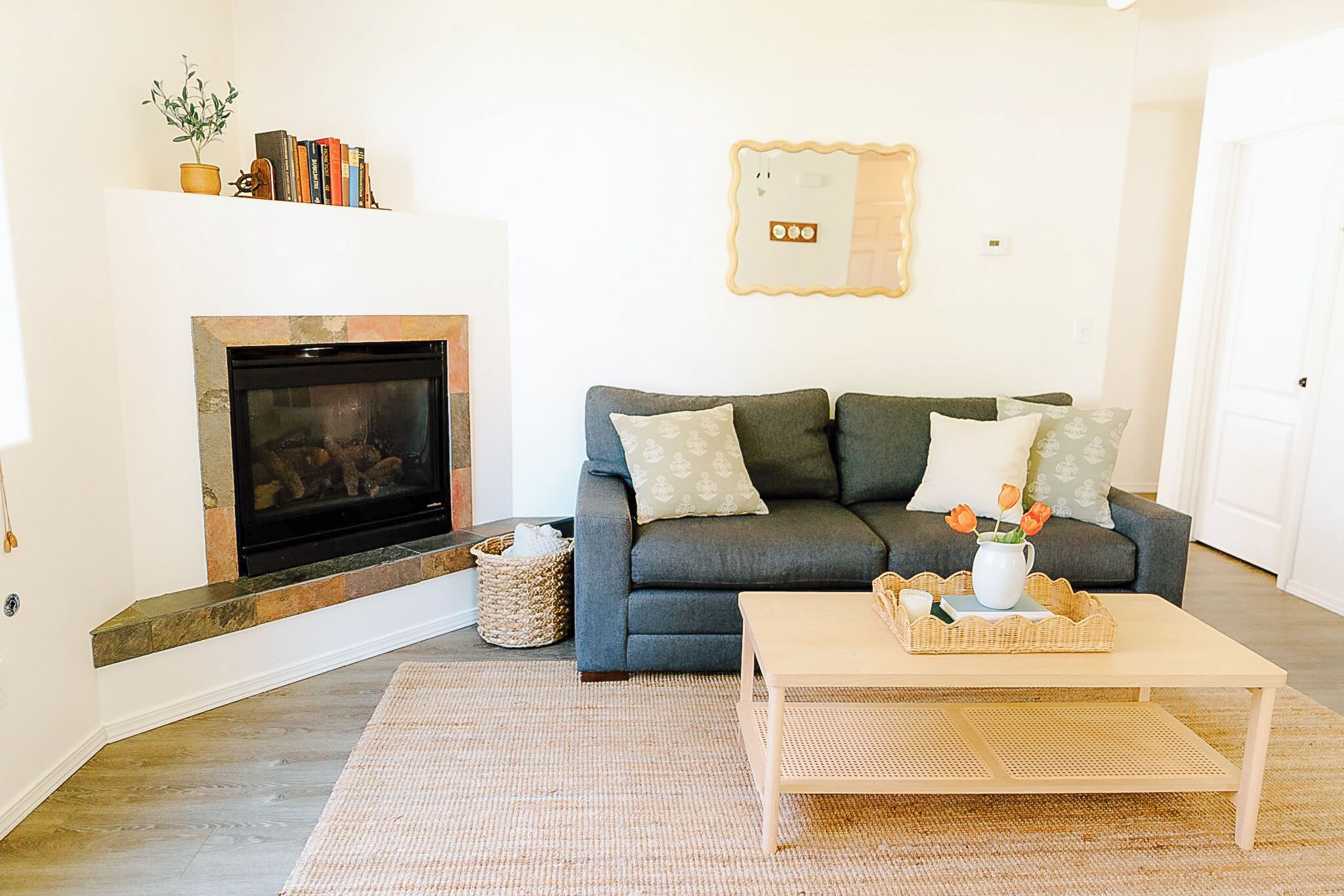 Ein Wohnzimmer mit Kamin, einer Couch, einem Couchtisch und einem Bücherregal.