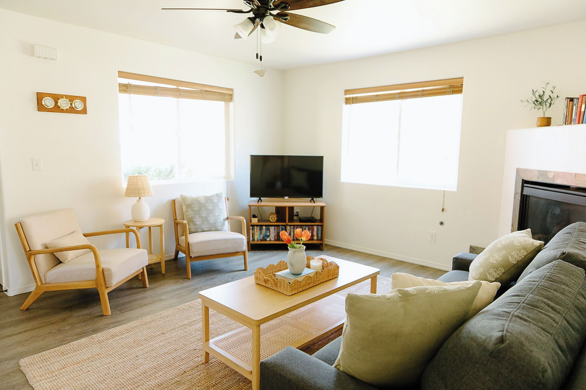 A living room with a sofa, chairs, a coffee table, a TV, and a fireplace.
