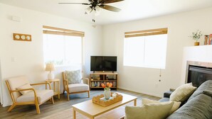 A living room with a sofa, chairs, a coffee table, a TV, and a fireplace. - The Lighthouse - Entire home in Moscow, Idaho (Moscow)