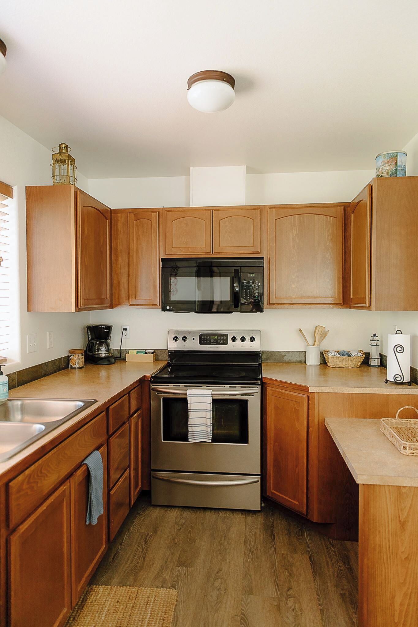 A kitchen with wooden cabinets, a stainless steel stove, a microwave, and a coffee maker.