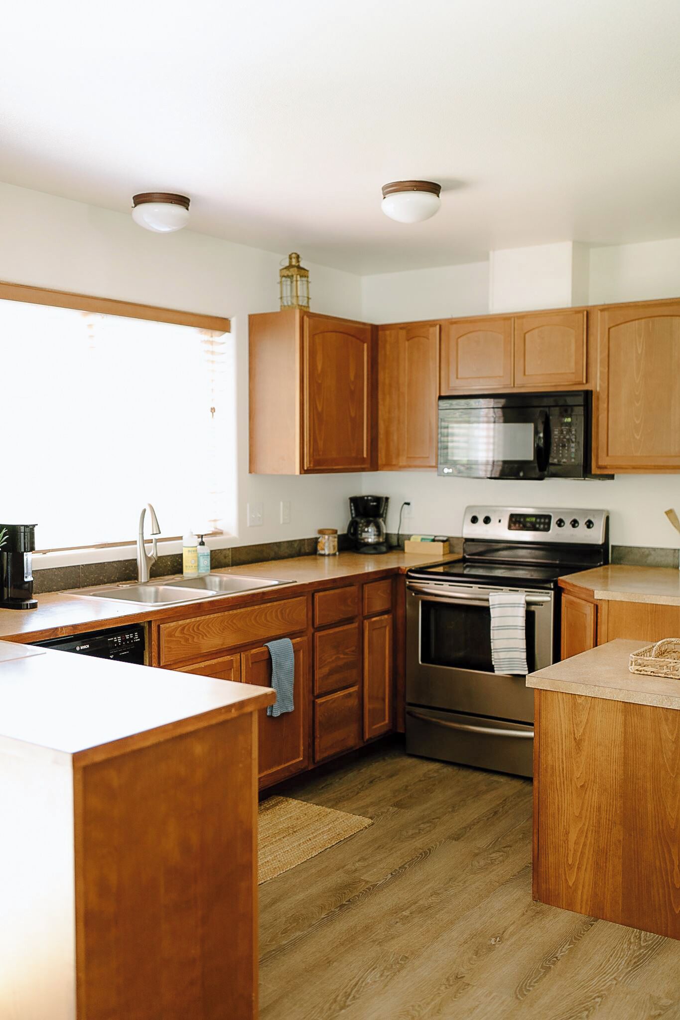 A kitchen with wooden cabinets, a stainless steel oven, a microwave, and a dishwasher.