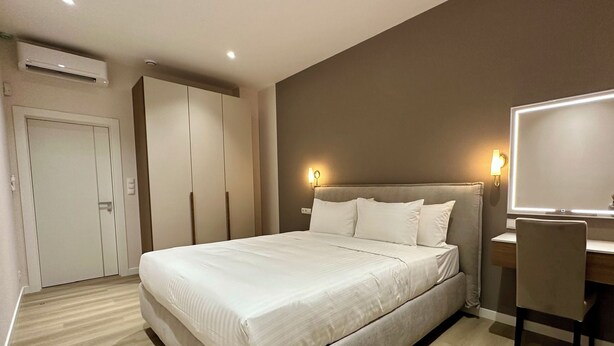 Une chambre à coucher moderne, avec un lit, un bureau et une armoire.