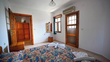 Une chambre à coucher comprenant un lit, une armoire, un miroir et un appareil de climatisation.