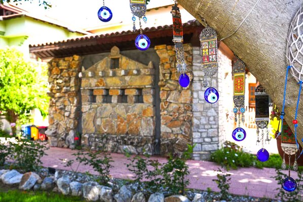 A stone building with a tiled roof, a stone wall, and a paved entrance. - Şahin Villa Apart (Ortaca)