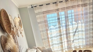 A living room with a sofa, a round coffee table, and decorative items on the walls. - Penthouse 2 bed 2 bath Marbella. Breathtaking sea & mountain views. (Ojén)