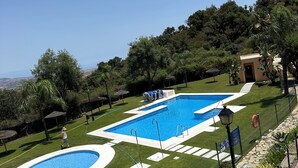 A swimming pool with a surrounding garden and a small building. - Penthouse 2 bed 2 bath Marbella. Breathtaking sea & mountain views. (Ojén)