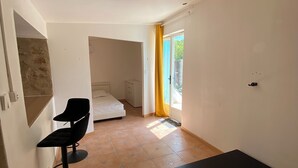Une chambre avec un lit, une chaise et un matelas posé sur le sol.