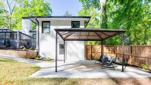 A house with a covered patio, a fenced backyard, and a wooden fence. - Entire Rental Unit - Cozy 1 BR/ 1 BA (Atlanta)