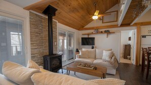 A cozy living room with a fireplace, a sofa, a coffee table, and a television.