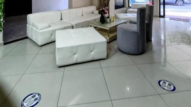 A modern lobby with a white sofa, a glass coffee table, and a grey ottoman. - Hotel Quinta Avenida  (Medellín)